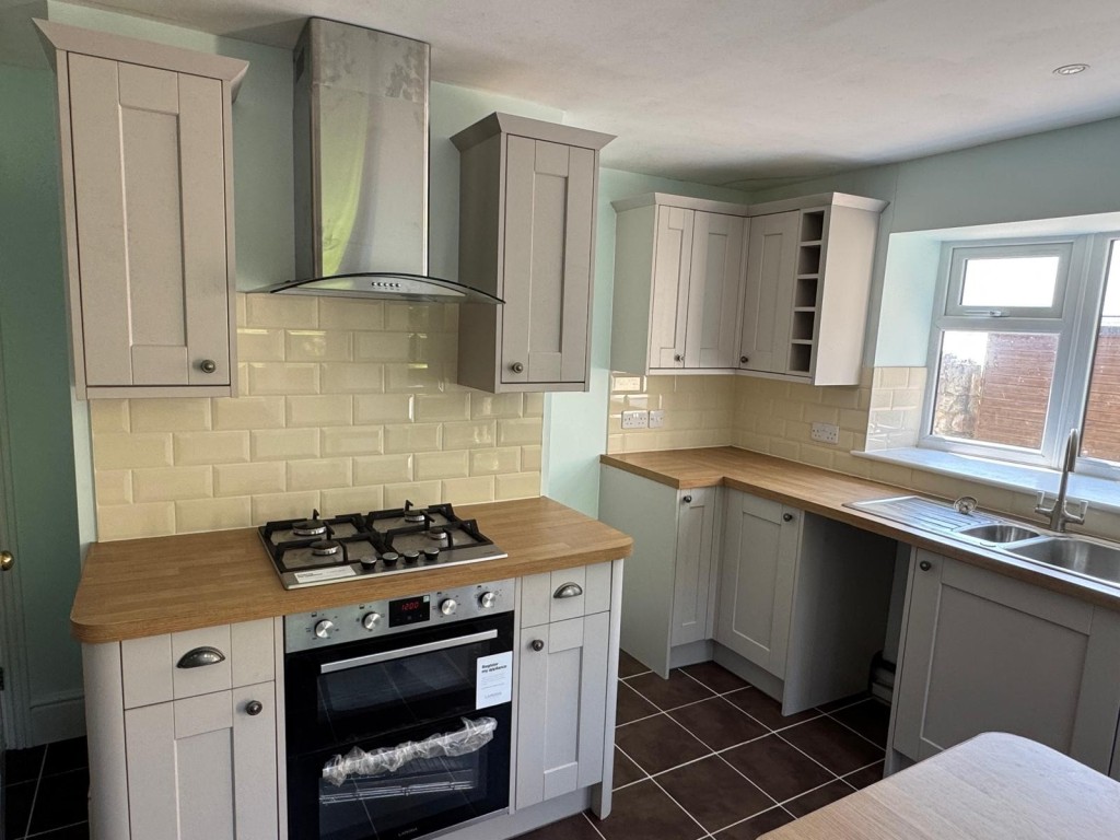 Lot: 88 - TWO-BEDROOM COTTAGE FOR IMPROVEMENT - A Reverse View of the Kitchen